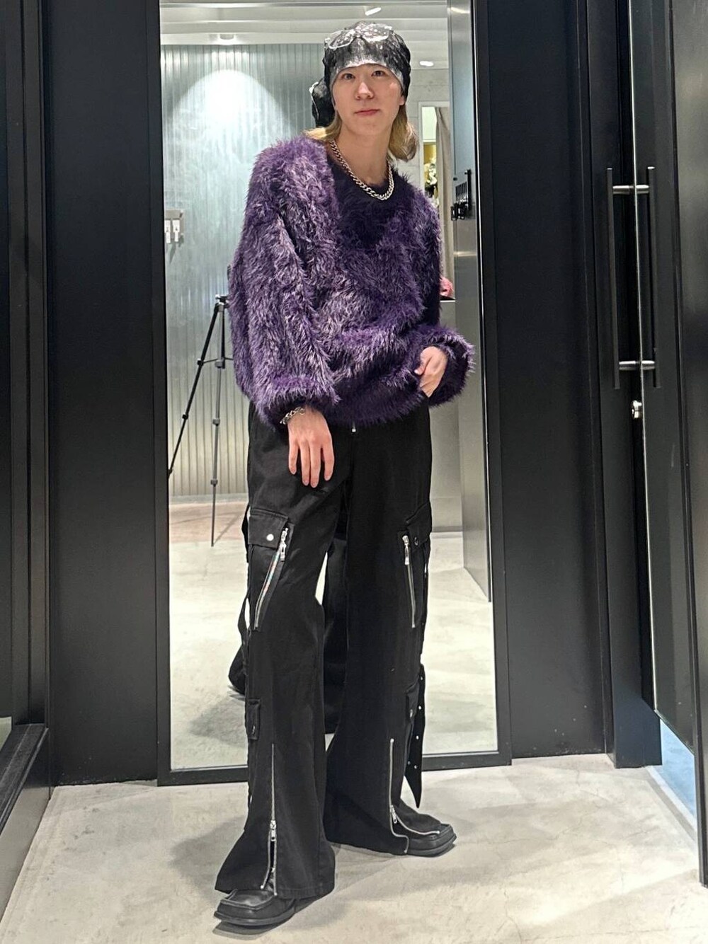 パープル系のニット/セーター、ブラック系のデニムパンツ、シルバー系のネックレスを着用したメンズの秋コーディネートの1枚目の写真