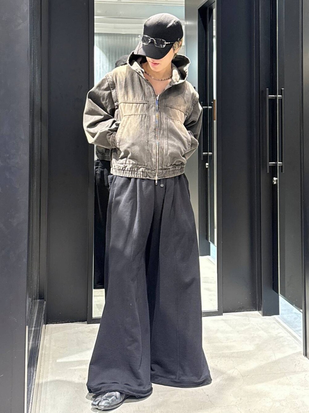 ブラック系のTシャツ/カットソー、ブラック系のスウェットパンツ、ブラウン系のブルゾンを着用したメンズの冬コーディネートの1枚目の写真