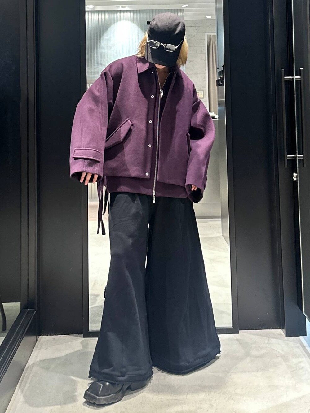 ブラック系のスウェットパンツ、パープル系のブルゾン、ブラック系のキャップを着用したメンズの秋コーディネートの1枚目の写真