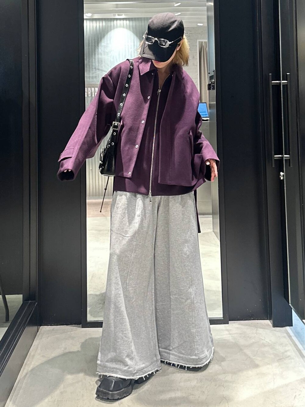 グレー系のスウェットパンツ、ブラック系のショルダーバッグ、パープル系のブルゾンを着用したメンズの秋コーディネートの1枚目の写真