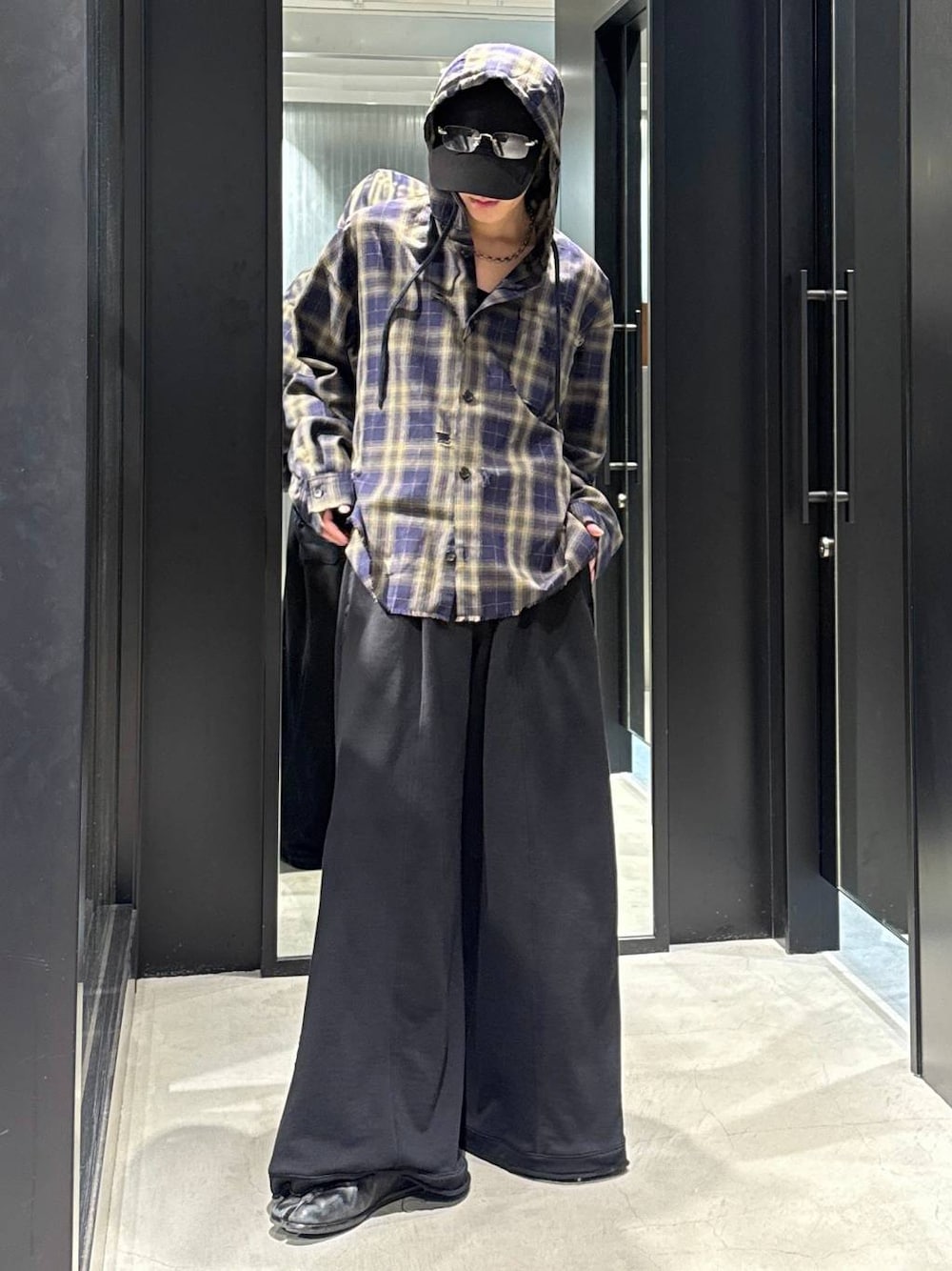 ブラック系のTシャツ/カットソー、ブラック系のスウェットパンツ、ブラック系のキャップを着用したメンズの冬コーディネートの1枚目の写真