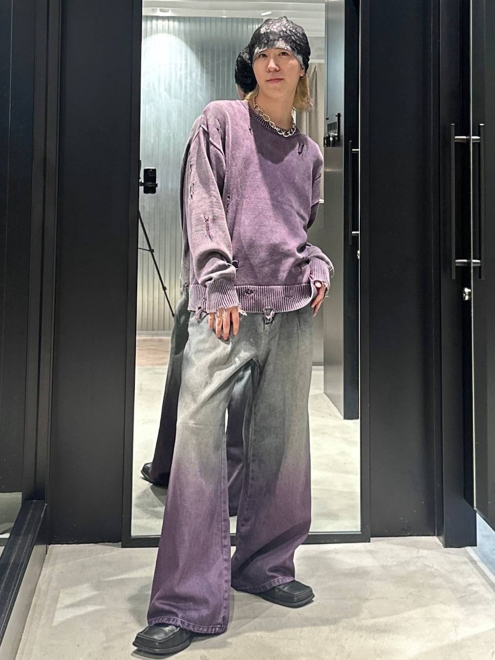 パープル系のデニムパンツ、パープル系のニット/セーター、シルバー系のネックレスを着用したメンズの秋コーディネートの1枚目の写真