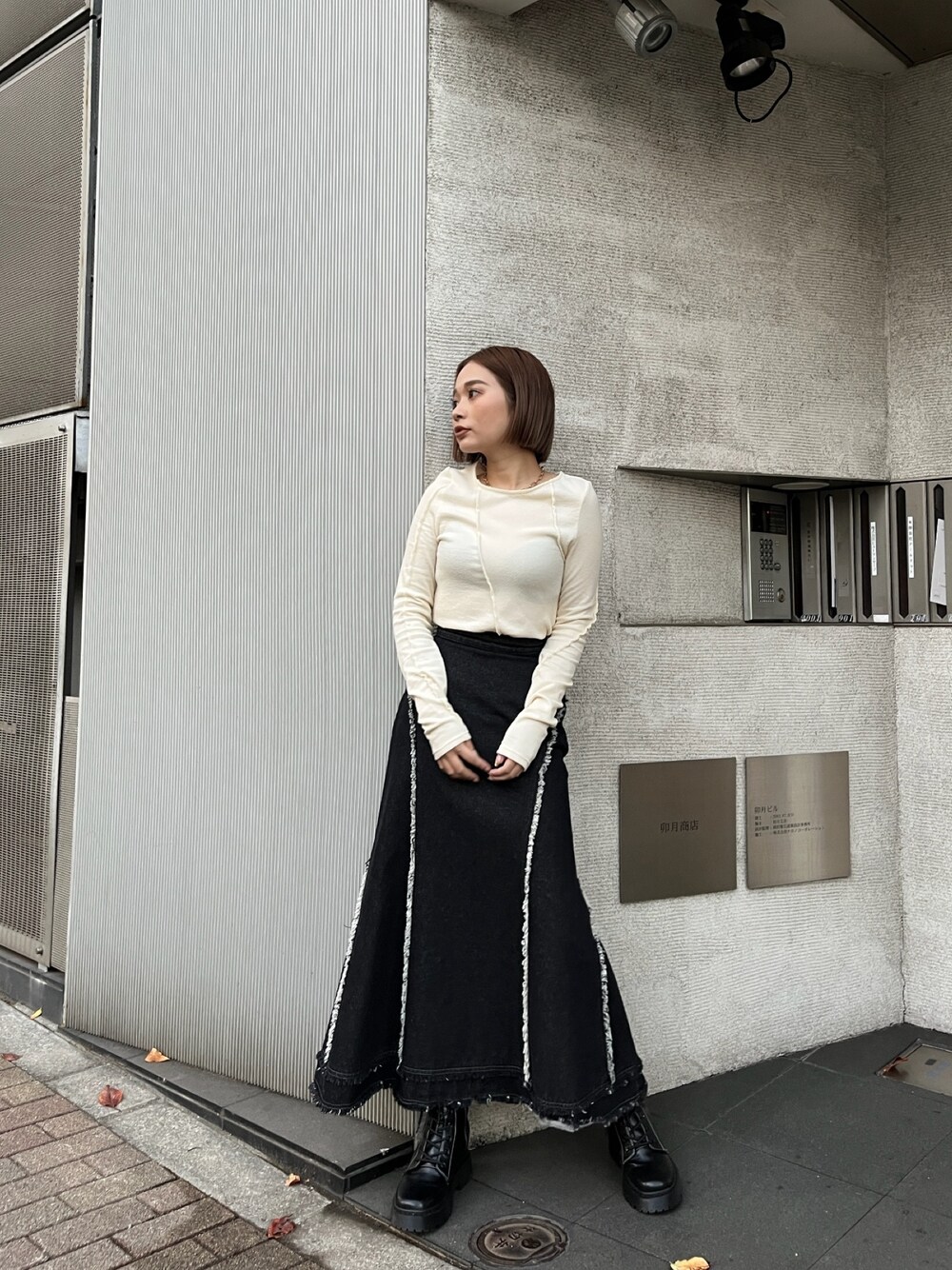 ホワイト系のTシャツ/カットソー、ブラック系のデニムスカートを着用したレディースの秋コーディネートの1枚目の写真