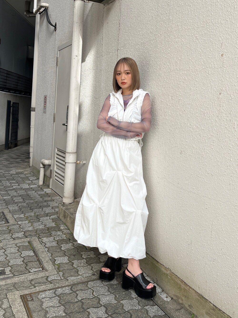 グレー系のTシャツ/カットソー、ホワイト系のベスト、ホワイト系のスカートを着用したレディースの冬コーディネートの1枚目の写真