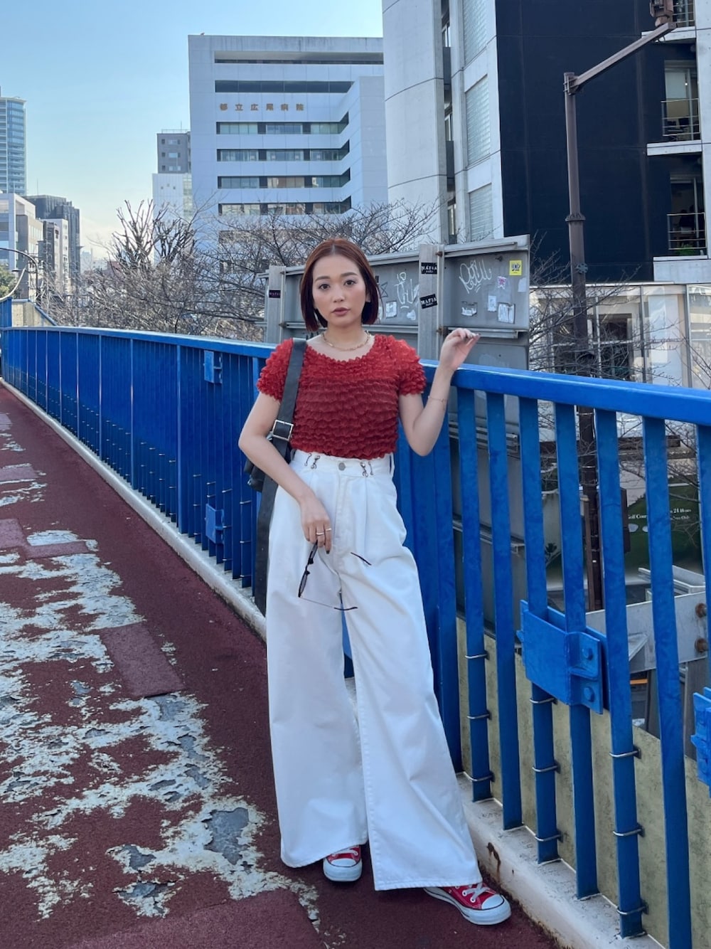 ホワイト系のデニムパンツ、ブラック系のショルダーバッグ、レッド系のシャツ/ブラウスを着用したレディースの春コーディネートの1枚目の写真