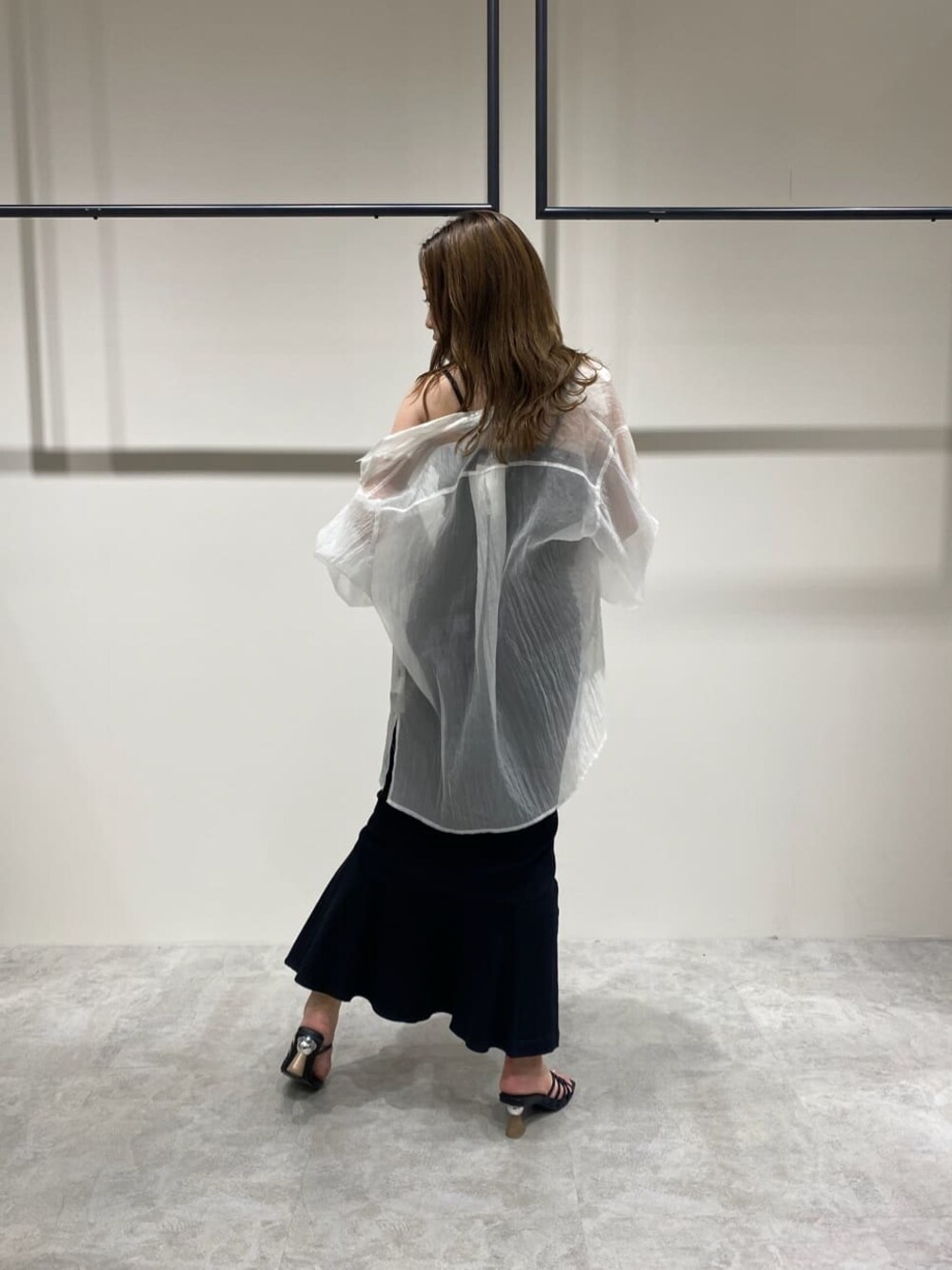 ブラック系のスカート、ホワイト系のシャツ/ブラウス、ブラック系のサンダルを着用したレディースの春コーディネートの1枚目の写真