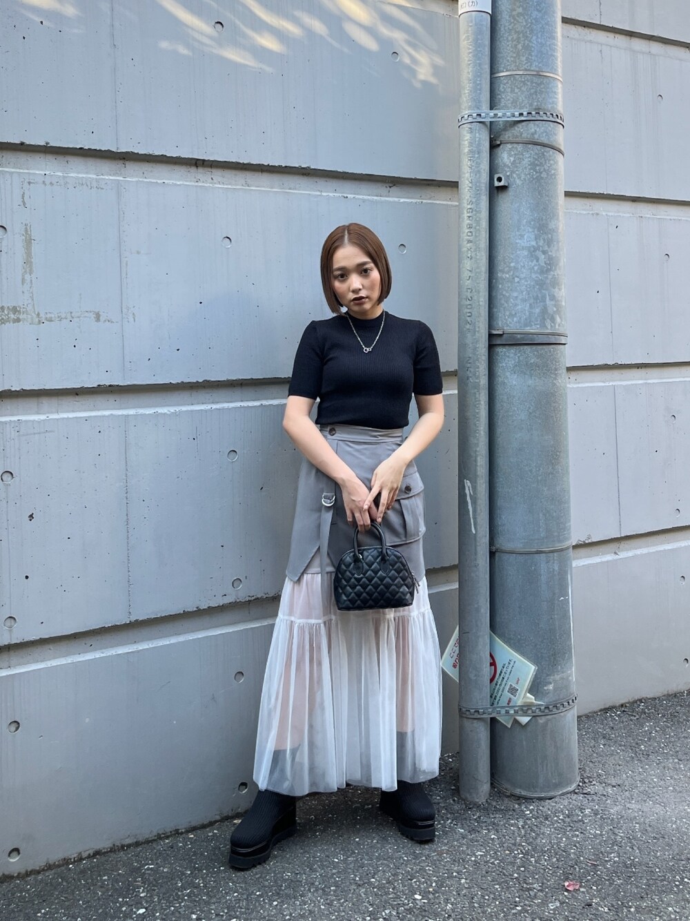 ブラック系のニット/セーター、ブラック系のブーツを着用したレディースの冬コーディネートの1枚目の写真