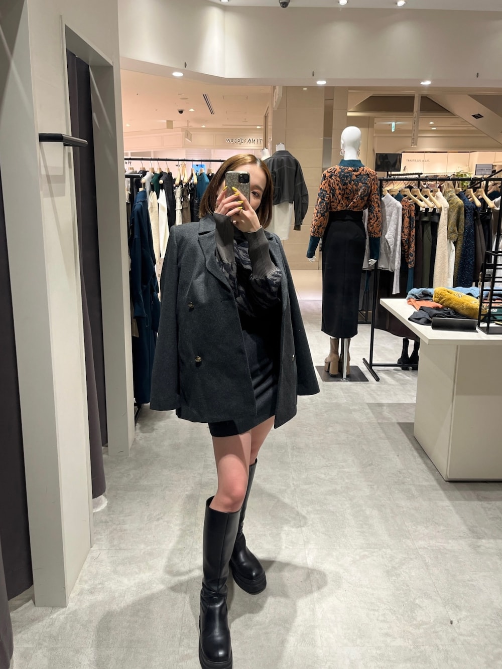 グレー系のテーラードジャケット、グレー系のスカート、グレー系のニット/セーターを着用したレディースの秋コーディネートの1枚目の写真