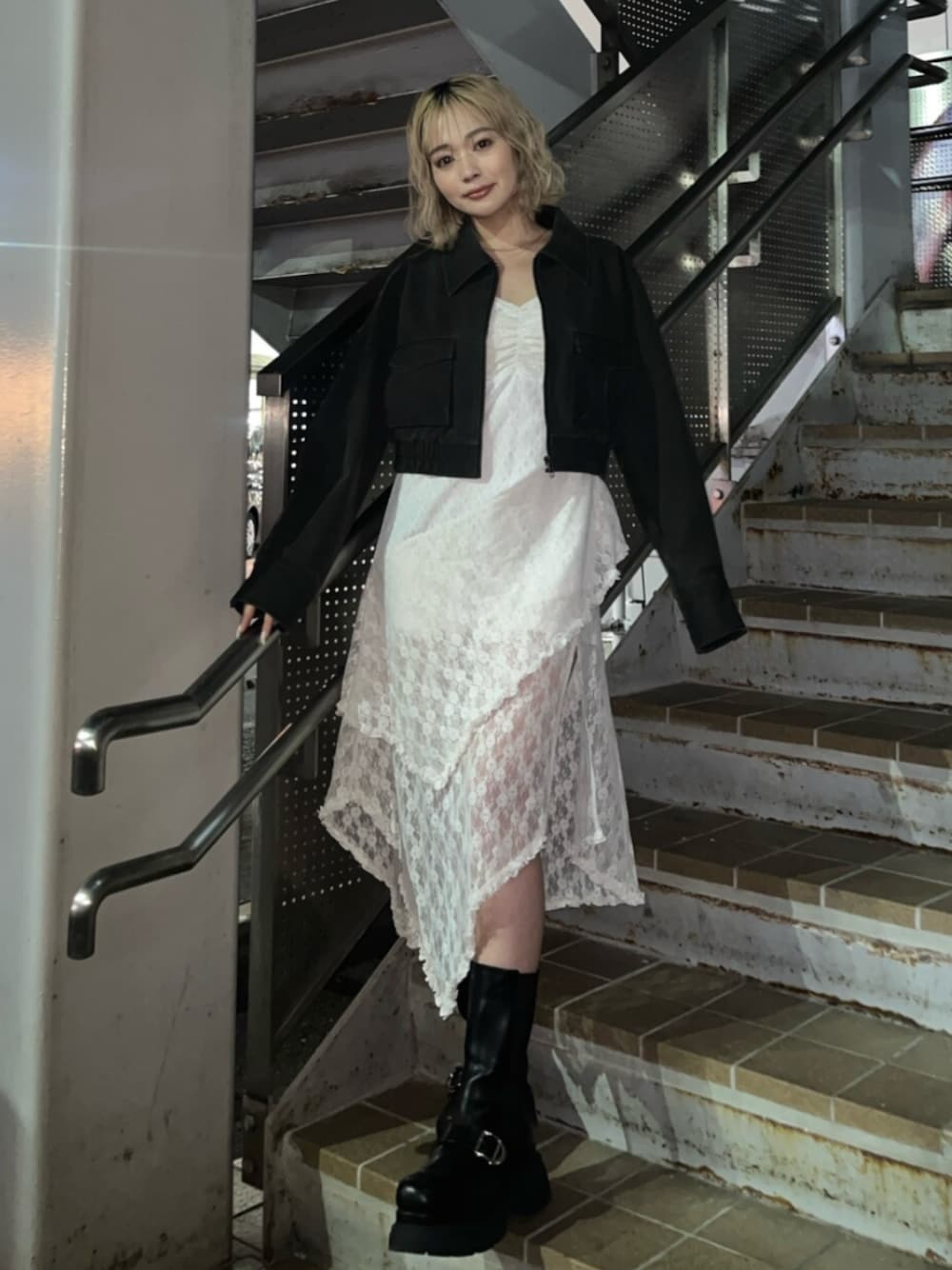 ブラック系のブーツ、ブラック系のブルゾンを着用したレディースの春コーディネートの1枚目の写真