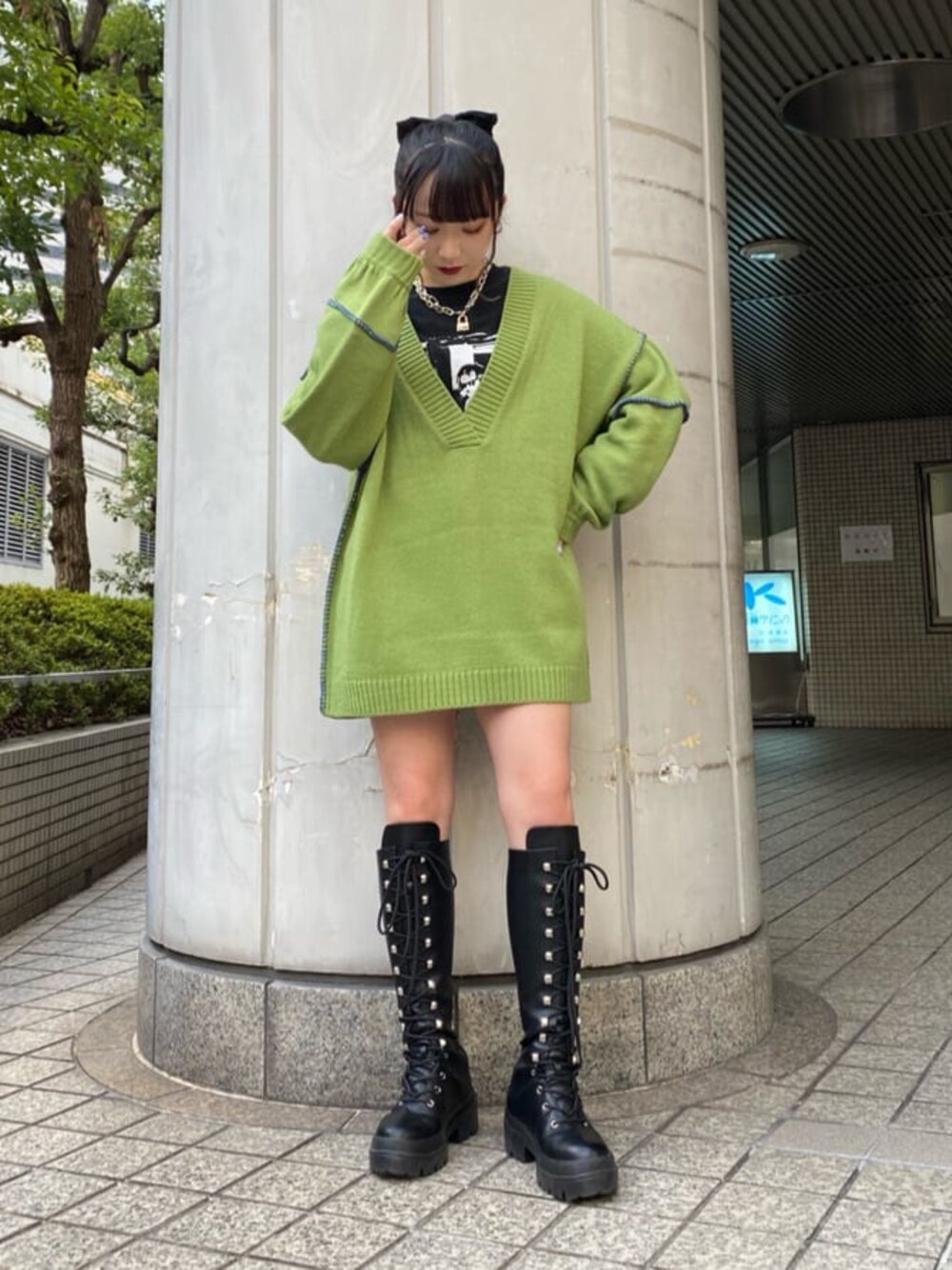 ブラック系のブーツ、グリーン系のニット/セーター、ブラック系のTシャツ/カットソーを着用したレディースの冬コーディネートの1枚目の写真