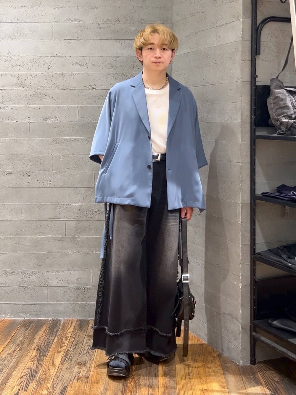 ブラック系のショルダーバッグ、ブルー系のテーラードジャケット、ブラック系のサンダルを着用したメンズの春コーディネートの1枚目の写真