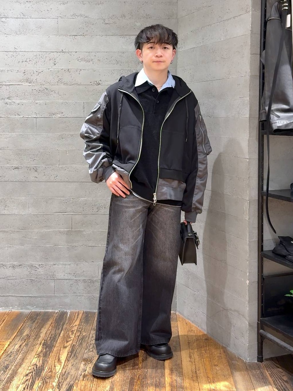 ブラック系のデニムパンツ、ブラック系のポロシャツ、ブラック系のローファーを着用したメンズの冬コーディネートの1枚目の写真