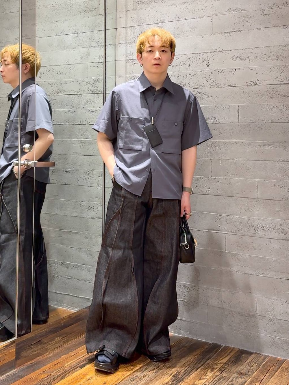 ブラック系のサンダル、ブラック系のデニムパンツ、ブラック系のショルダーバッグを着用したメンズの春コーディネートの1枚目の写真