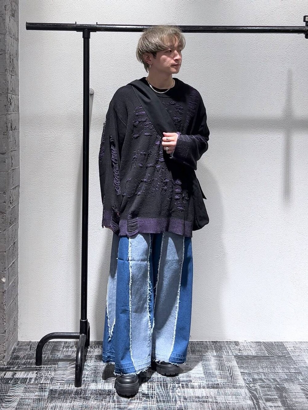 ブラック系のショルダーバッグ、ブラック系のスニーカー、ブルー系のデニムパンツを着用したメンズの冬コーディネートの1枚目の写真
