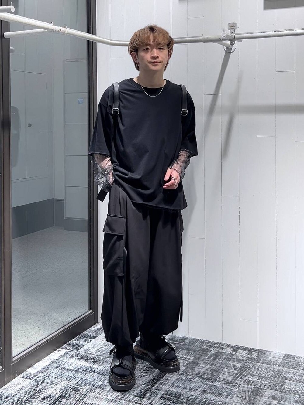 ブラック系のTシャツ/カットソー、ブラック系のサンダル、ブラック系のカーゴパンツを着用したメンズの春コーディネートの1枚目の写真