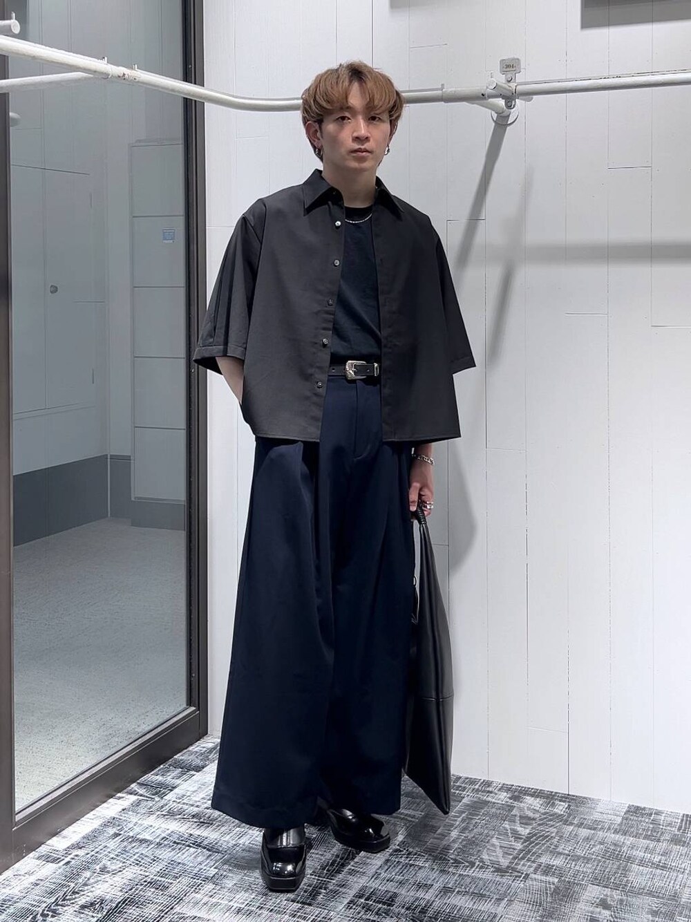 ブラック系のドレスシューズ、ブラック系のトートバッグ、ブラック系のTシャツ/カットソーを着用したメンズの春コーディネートの1枚目の写真