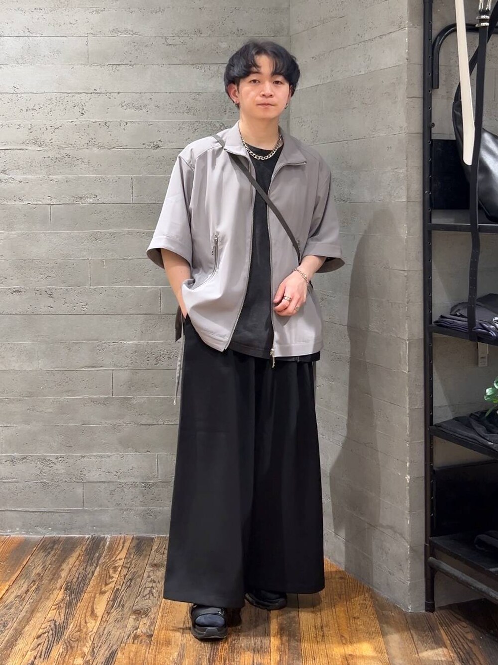 ブラック系のサンダル、グレー系のショルダーバッグ、ブラック系のスラックスを着用したメンズの春コーディネートの1枚目の写真
