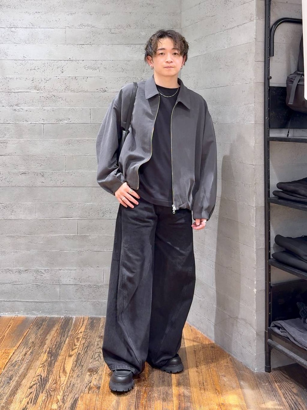 ブラック系のデニムパンツ、ブラック系のドレスシューズ、ブラック系のショルダーバッグを着用したメンズの秋コーディネートの1枚目の写真