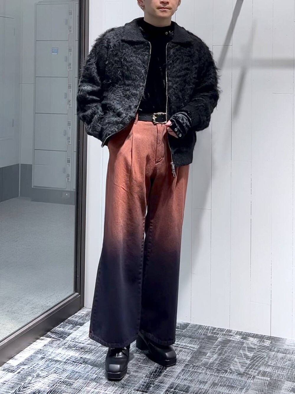 オレンジ系のデニムパンツ、ブラック系のTシャツ/カットソー、ブラック系のブーツを着用したメンズの冬コーディネートの1枚目の写真