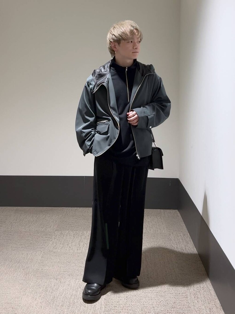 ブラック系のスラックス、ブラック系のショルダーバッグ、ブラック系のドレスシューズを着用したメンズの冬コーディネートの1枚目の写真