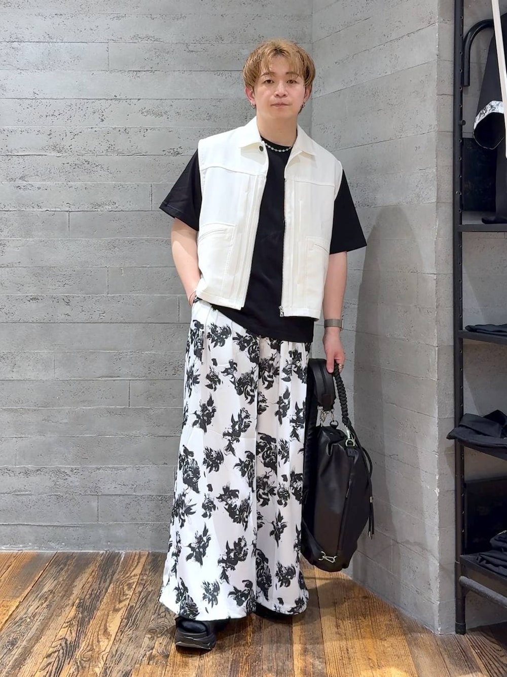 ブラック系のTシャツ/カットソー、ブラック系のサンダル、ホワイト系のスラックスを着用したメンズの夏コーディネートの1枚目の写真