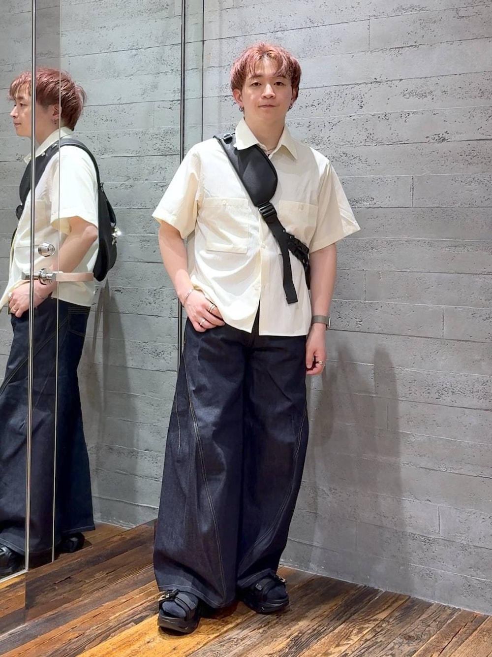 ブラック系のサンダル、ブルー系のデニムパンツ、ブラック系のショルダーバッグを着用したメンズの夏コーディネートの1枚目の写真