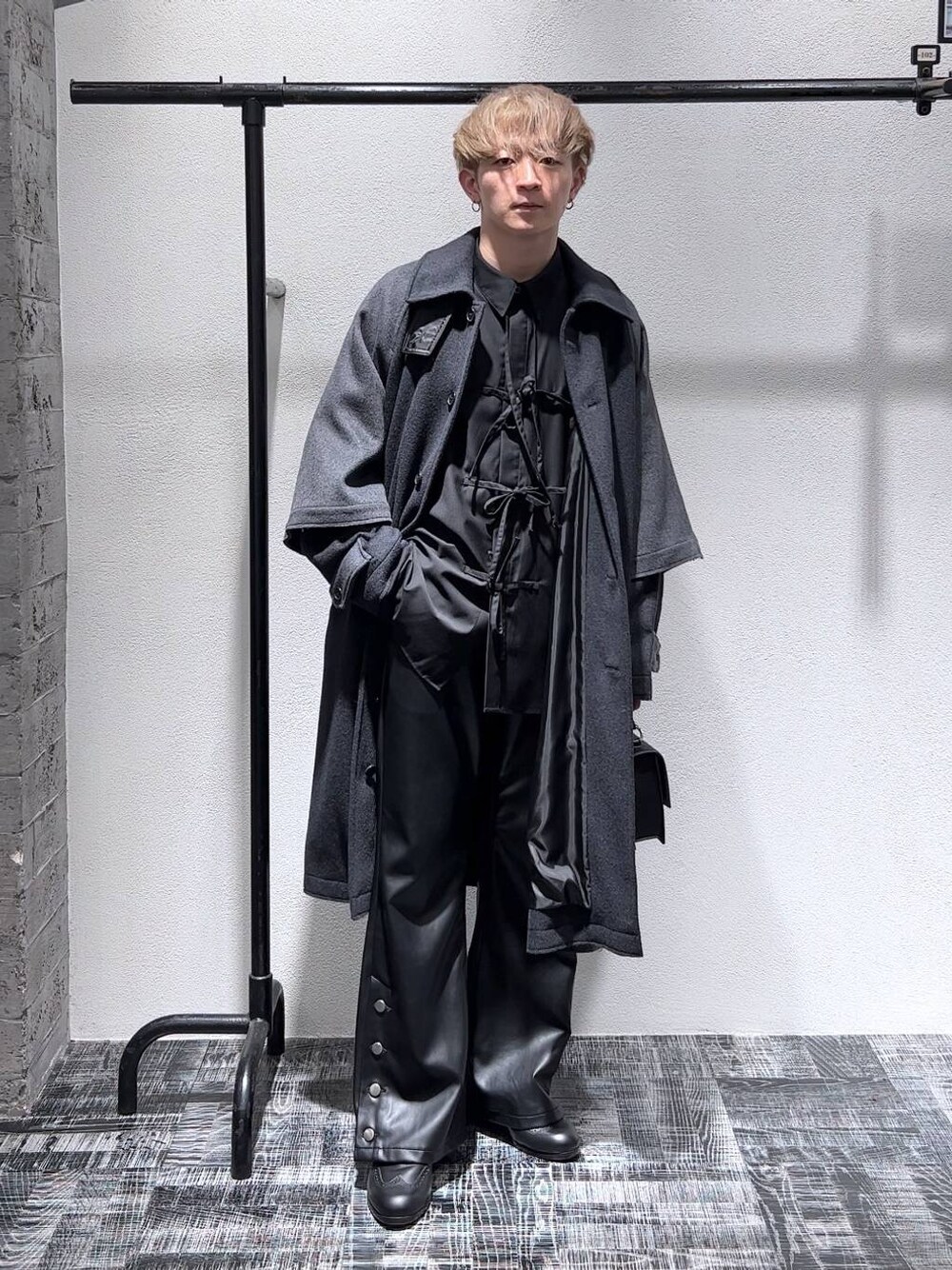 ブラック系のショルダーバッグ、ブラック系のドレスシューズ、ブラック系のその他パンツを着用したメンズの秋コーディネートの1枚目の写真