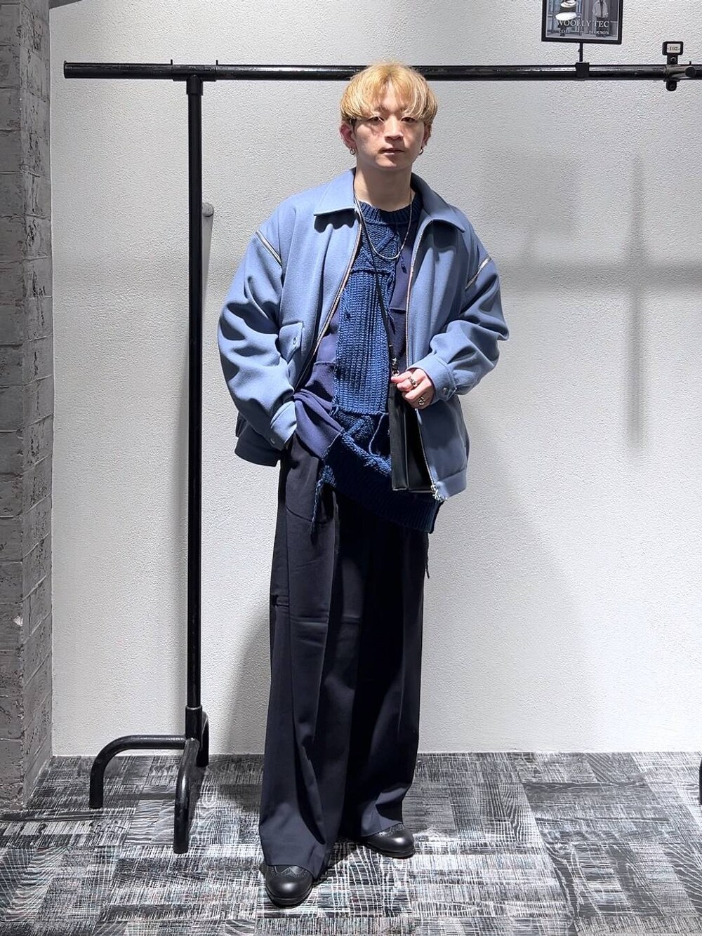 ブラック系のショルダーバッグ、ブラック系のドレスシューズ、ブルー系のブルゾンを着用したメンズの冬コーディネートの1枚目の写真