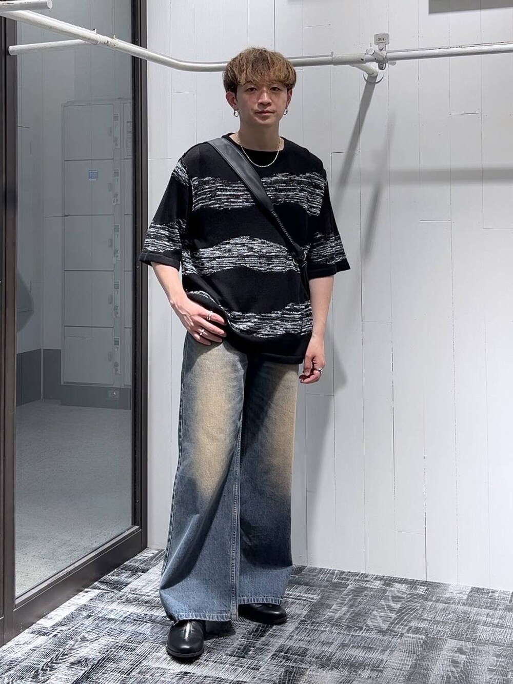 ブルー系のデニムパンツ、ブラック系のショルダーバッグ、ブラック系のニット/セーターを着用したメンズの夏コーディネートの1枚目の写真