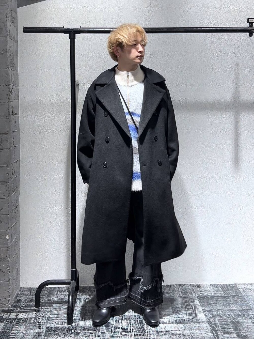 ブラック系のドレスシューズ、ブラック系のステンカラーコート、ブラック系のショルダーバッグを着用したメンズの冬コーディネートの1枚目の写真