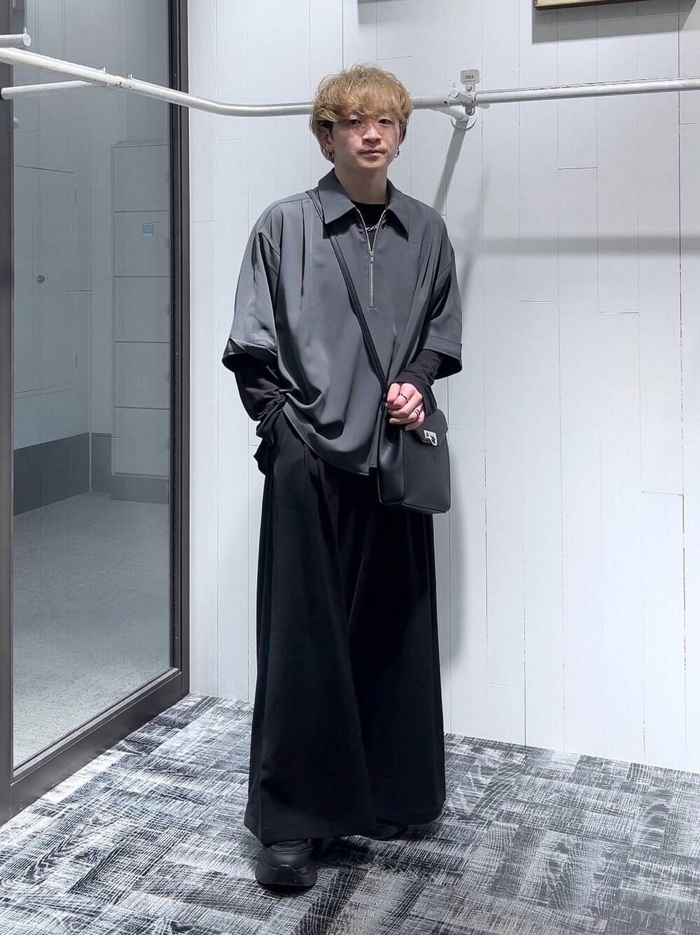 ブラック系のTシャツ/カットソー、ブラック系のショルダーバッグ、ブラック系のスラックスを着用したメンズの春コーディネートの1枚目の写真
