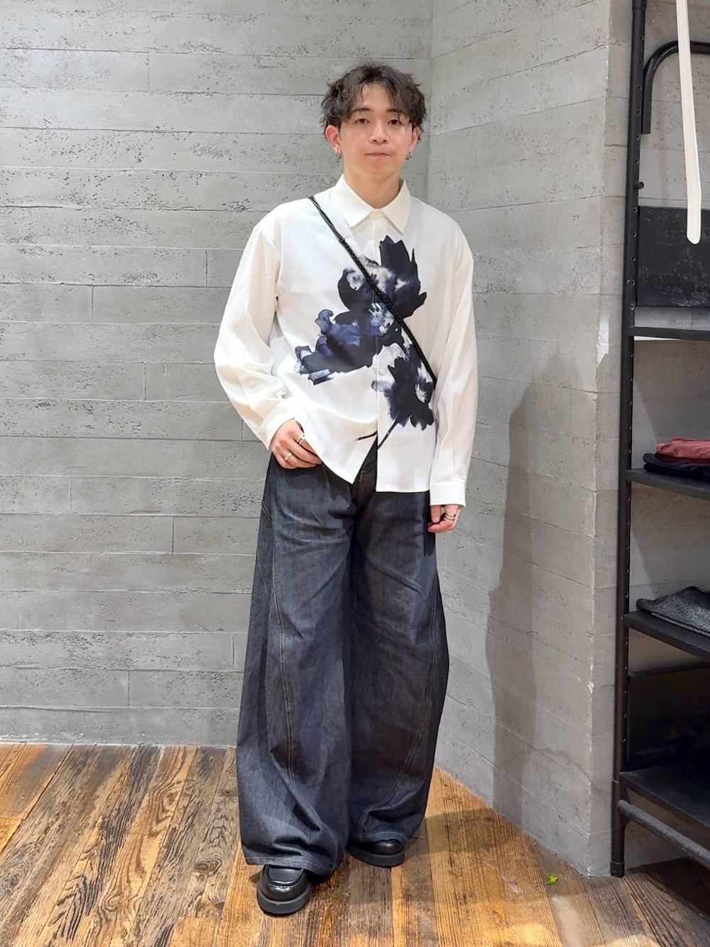 ブルー系のデニムパンツ、ブラック系のローファー、ブラック系のショルダーバッグを着用したメンズの秋コーディネートの1枚目の写真