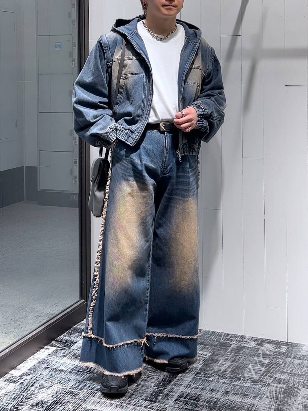 ブルー系のデニムパンツ、グレー系のショルダーバッグ、ホワイト系のTシャツ/カットソーを着用したメンズの冬コーディネートの1枚目の写真