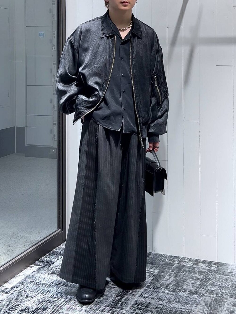 ブラック系のショルダーバッグ、ブラック系のその他パンツ、ブラック系のドレスシューズを着用したメンズの冬コーディネートの1枚目の写真