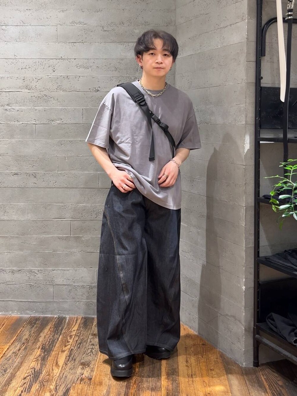 ブルー系のデニムパンツ、ブラック系のショルダーバッグ、グレー系のTシャツ/カットソーを着用したメンズの春コーディネートの1枚目の写真