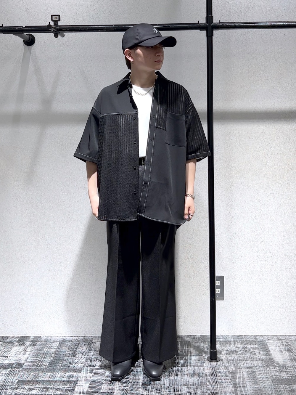 ブラック系のシャツ/ブラウス、ブラック系のスラックス、ブラック系のキャップを着用したメンズの春コーディネートの1枚目の写真