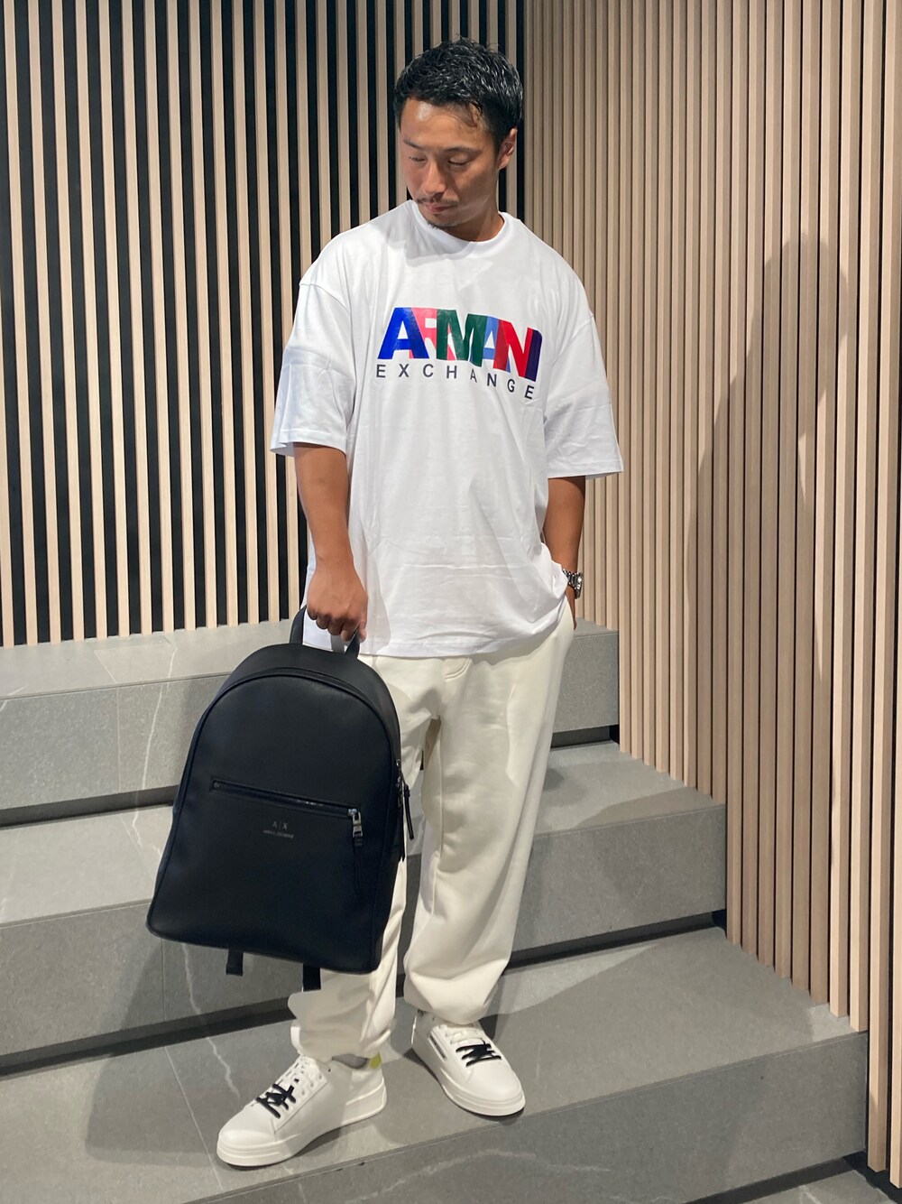 「AXchange、armaniexchange、AXCatStreet、AXchanger、Tシャツ、パンツスタイル、スウェットパンツ、バックパック、モノトーン、白Tシャツ、スニーカー、お出かけコーデ、休日コーデ、バックプリント、オーバーサイズ」｜「ARMANI EXCHANGEの【A|X アルマーニ エクスチェンジ】カラフルロゴ　半袖クルーネックTシャツ/COMFORT（Tシャツ/カットソー、ホワイト系）」を使った、Y. SHOTAROさん（メンズ・163cm）の夏コーディネートの1枚目の写真
