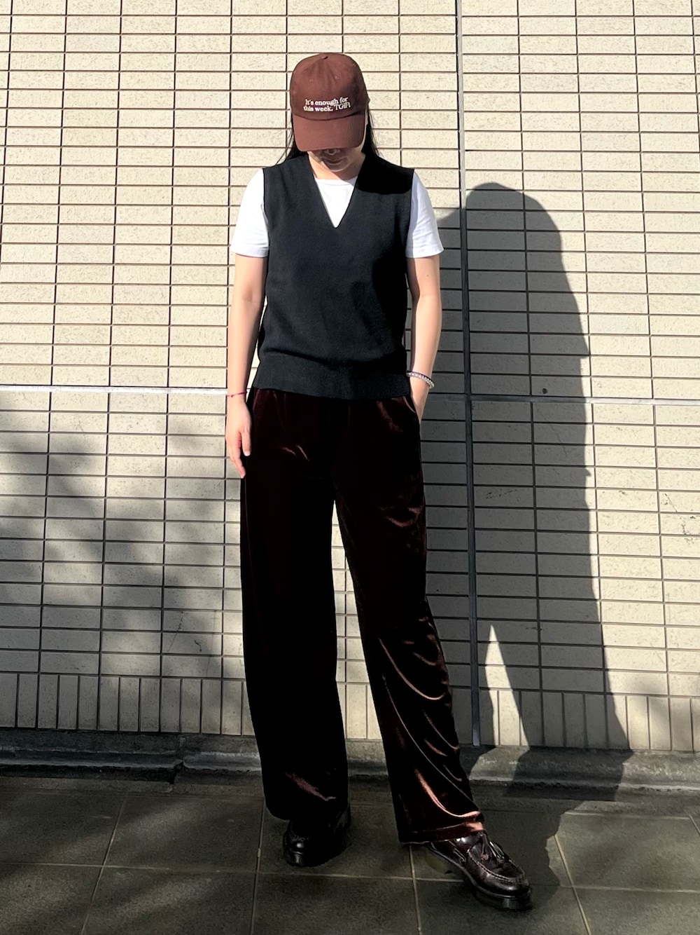 ブラック系のベスト、ブラウン系のパンツ、ブラウン系のローファーを着用したレディースの秋コーディネートの1枚目の写真