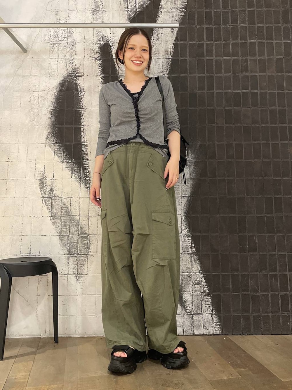 グリーン系のカーゴパンツ、ブラック系のバックパック/リュック、グレー系のカーディガン/ボレロを着用したレディースの夏コーディネートの1枚目の写真
