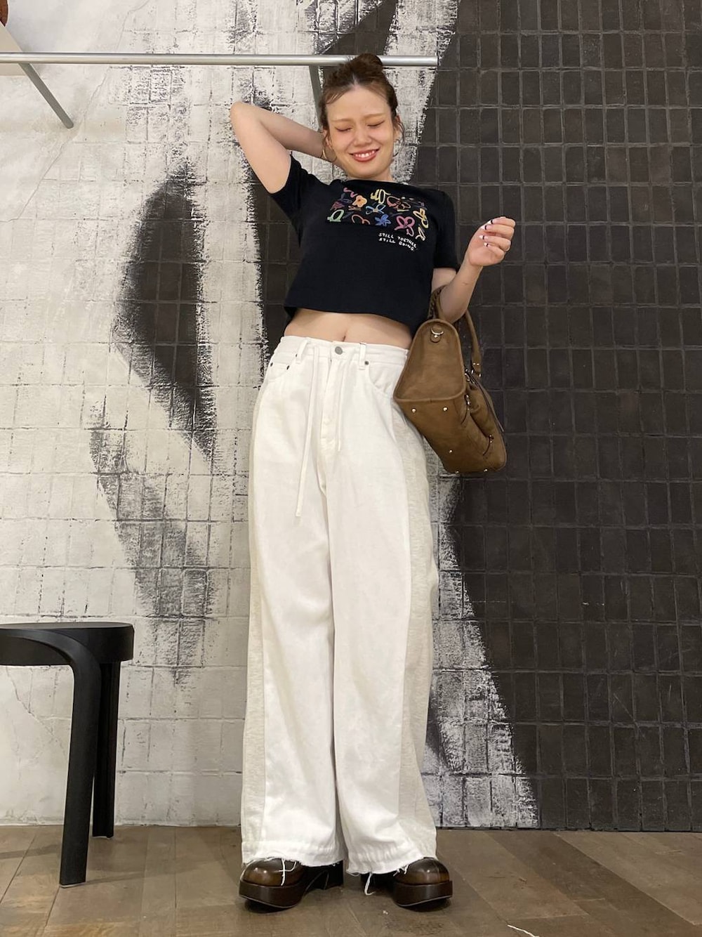 ブラック系のTシャツ/カットソー、ホワイト系のデニムパンツ、ブラウン系のボストンバッグを着用したレディースの夏コーディネートの1枚目の写真