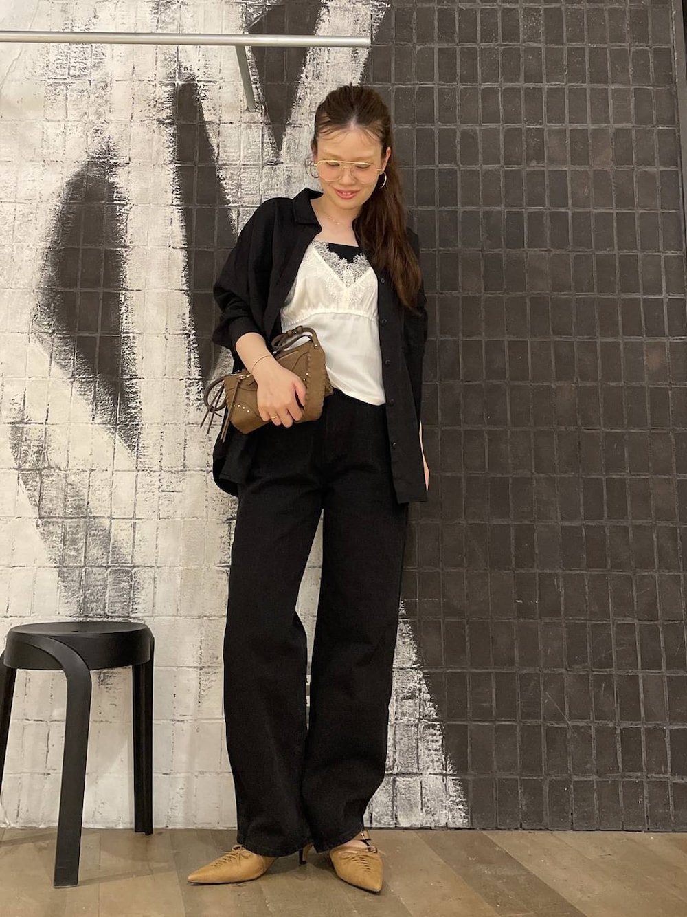 ブラック系のデニムパンツ、ホワイト系のキャミソール、ベージュ系のパンプスを着用したレディースの秋コーディネートの1枚目の写真