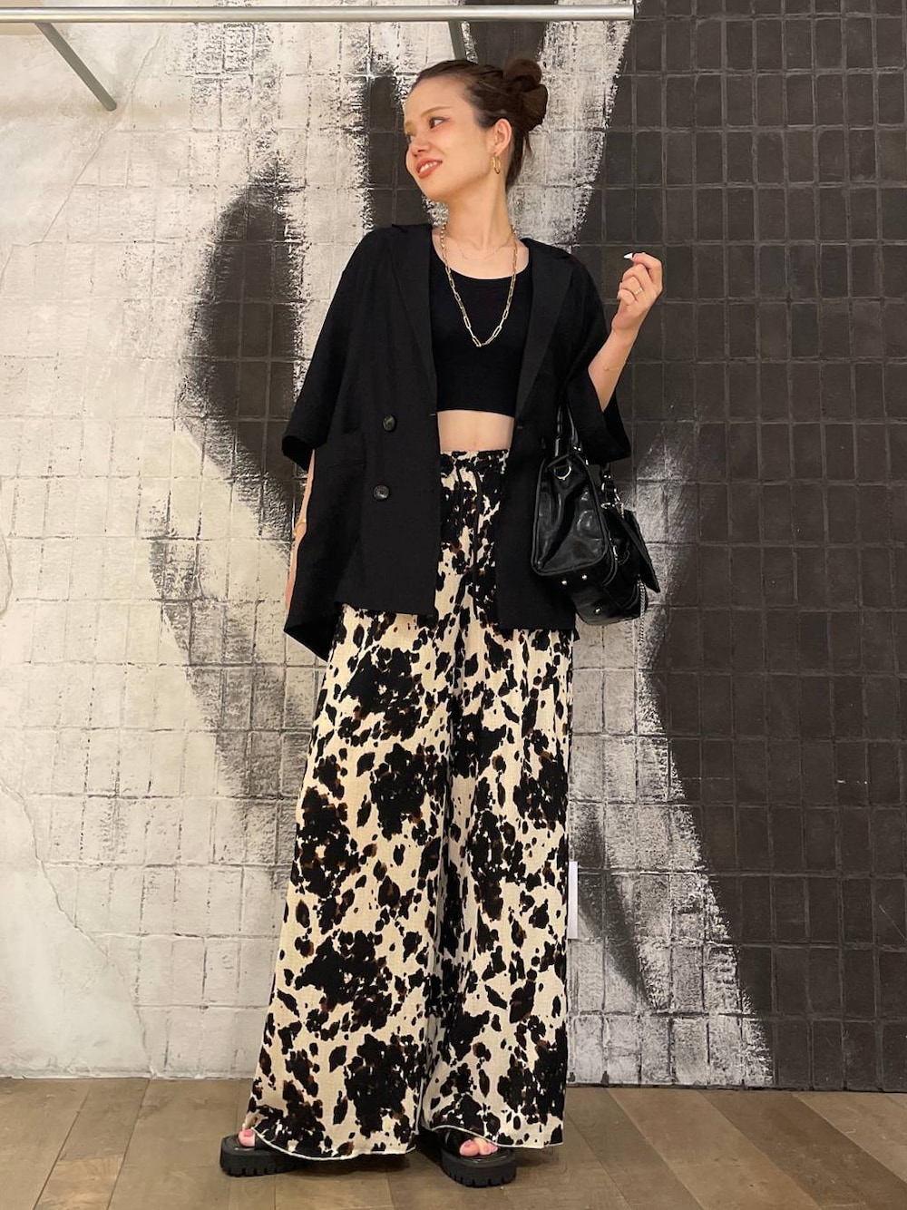 ブラック系のタンクトップ、ブラック系のボストンバッグ、ブラック系のサンダルを着用したレディースの夏コーディネートの1枚目の写真