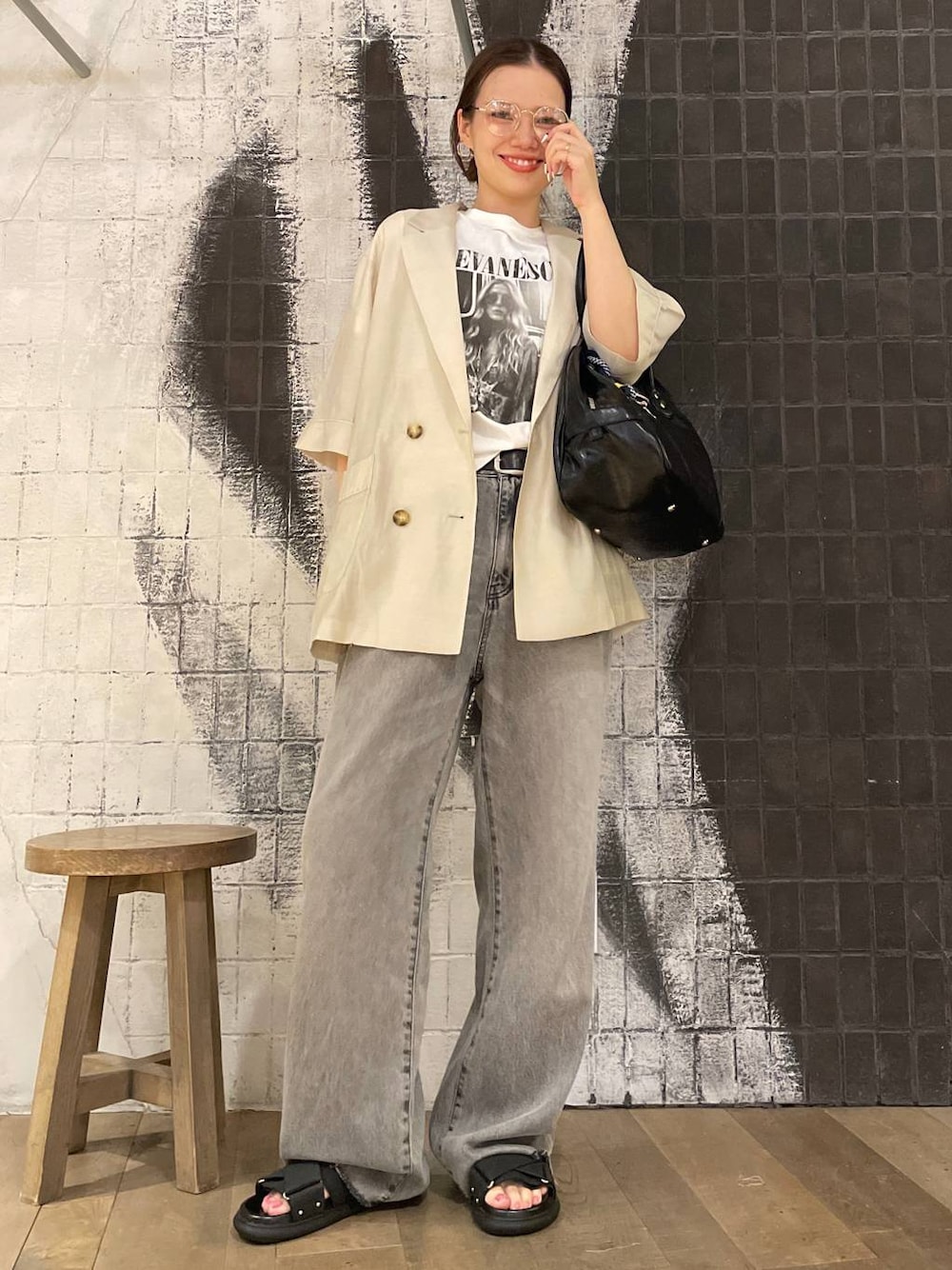 グレー系のデニムパンツ、ブラック系のボストンバッグ、ホワイト系のTシャツ/カットソーを着用したレディースの夏コーディネートの1枚目の写真