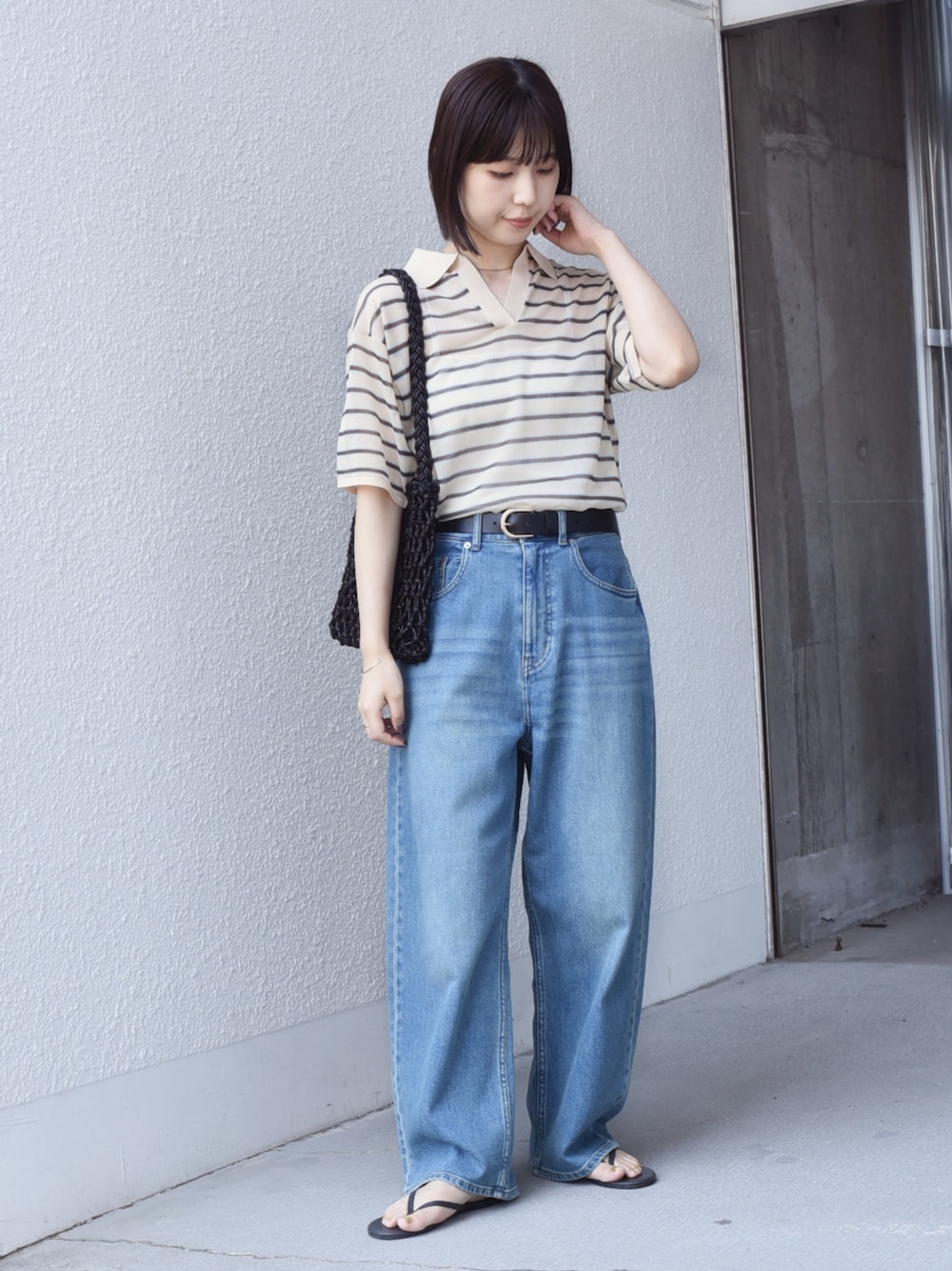 ブルー系のデニムパンツ、ベージュ系のニット/セーターを着用したレディースの夏コーディネートの1枚目の写真
