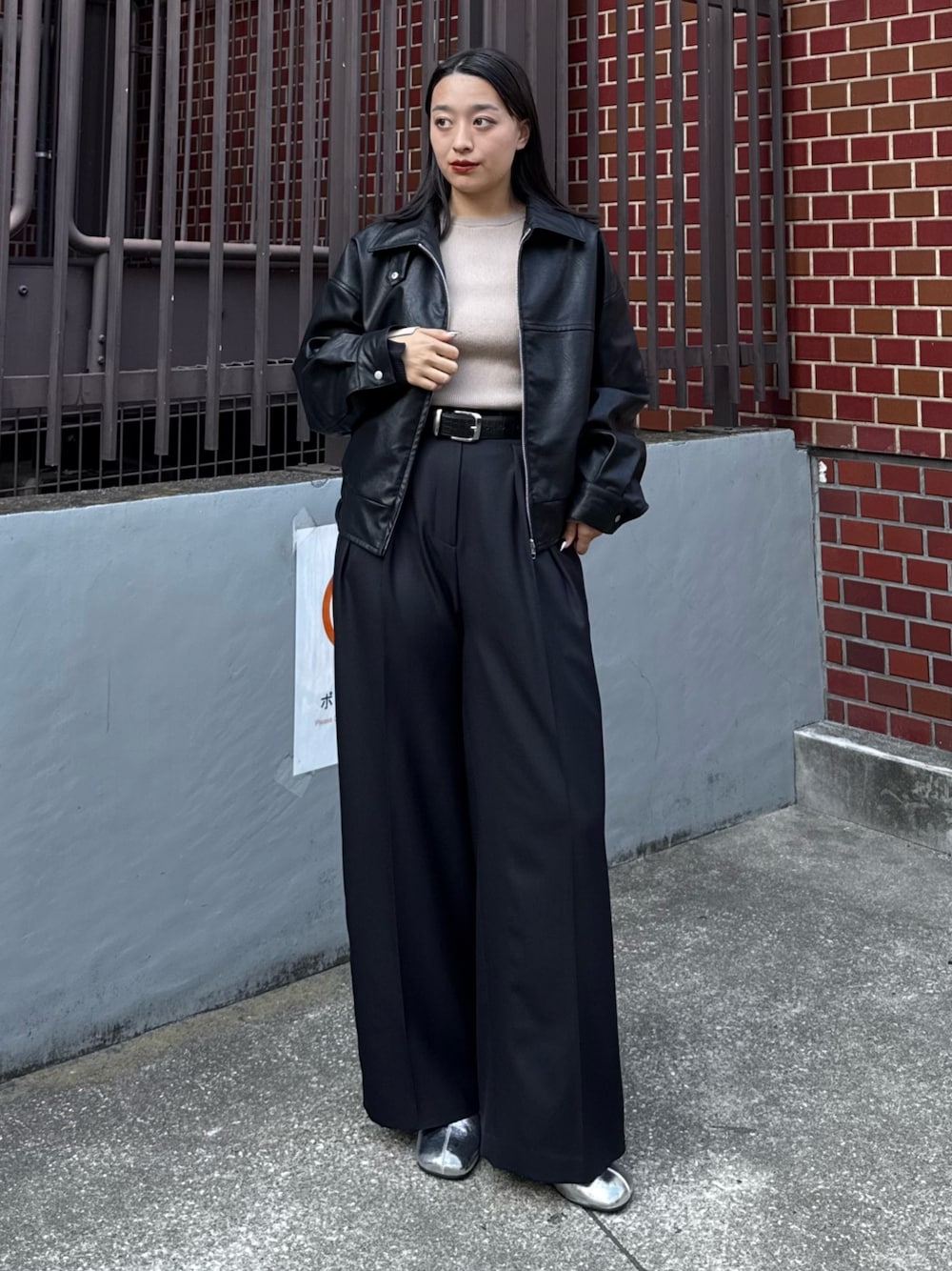 ブラック系のブルゾン、ベージュ系のニット/セーター、ブラック系のスラックスを着用したレディースの秋コーディネートの1枚目の写真