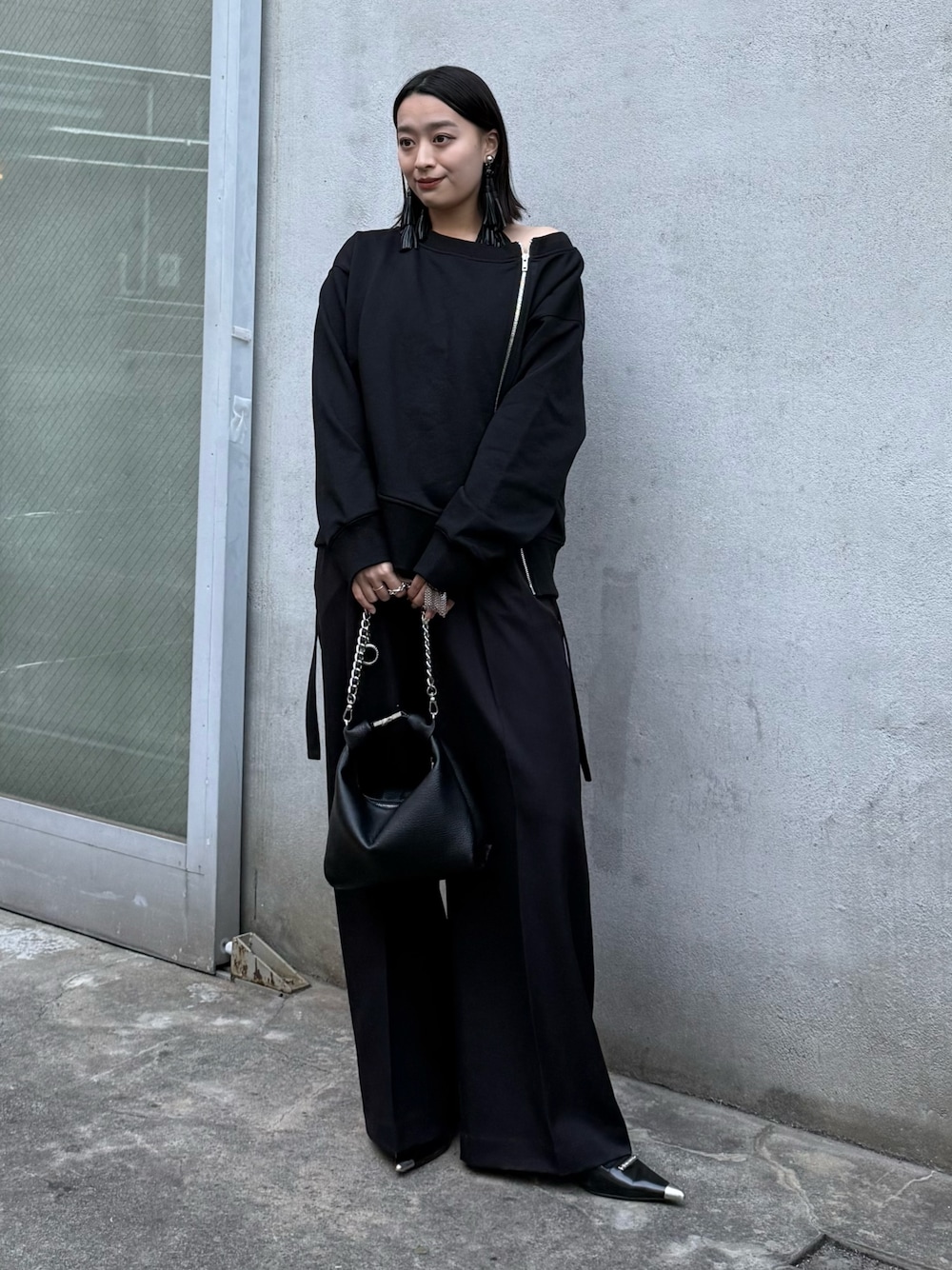 ブラック系のTシャツ/カットソー、ブラック系のスラックス、ブラック系のトートバッグを着用したレディースの冬コーディネートの1枚目の写真