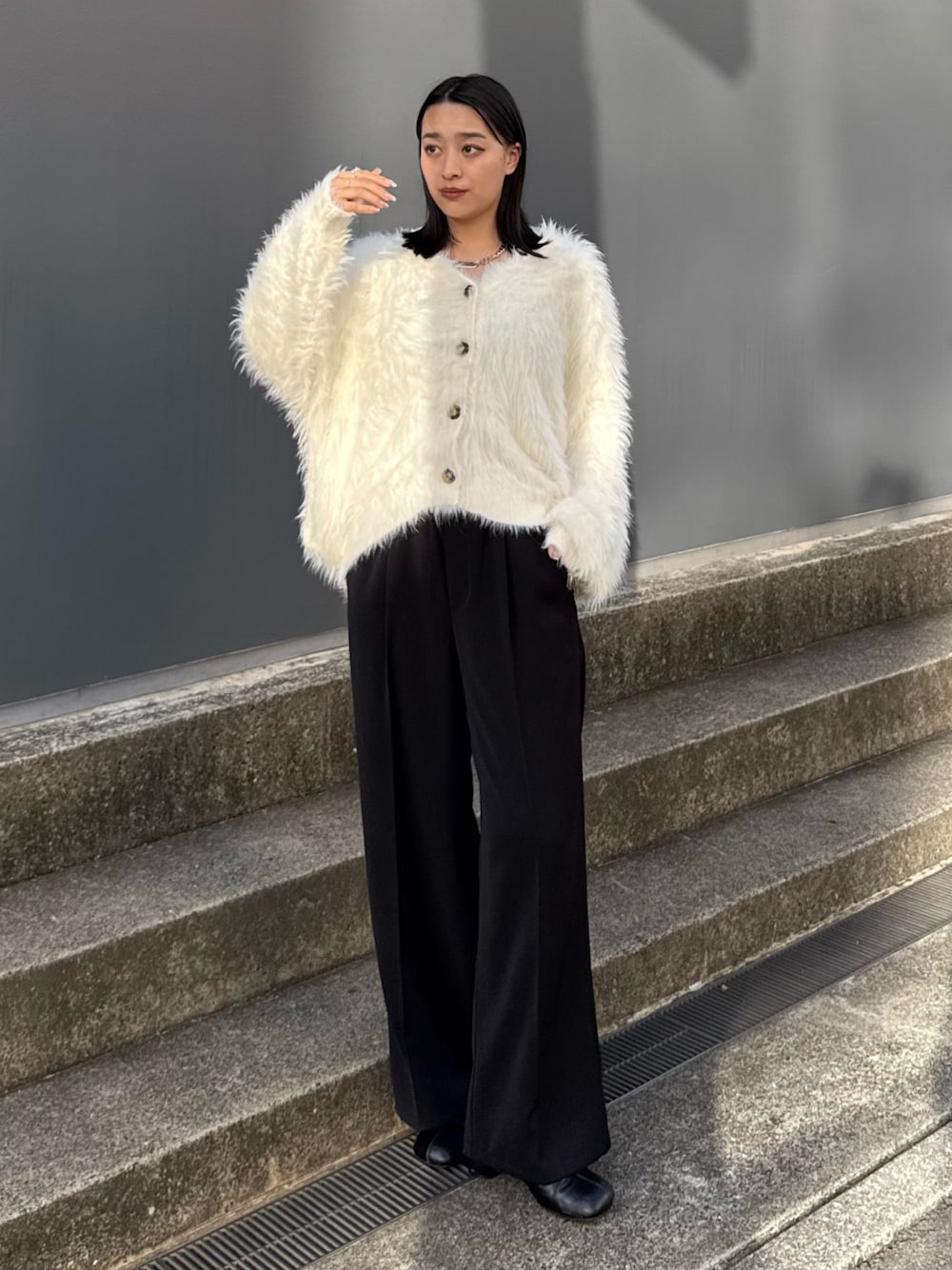 ブラック系のスラックス、ブラック系のブーツ、ホワイト系のカーディガン/ボレロを着用したレディースの夏コーディネートの1枚目の写真