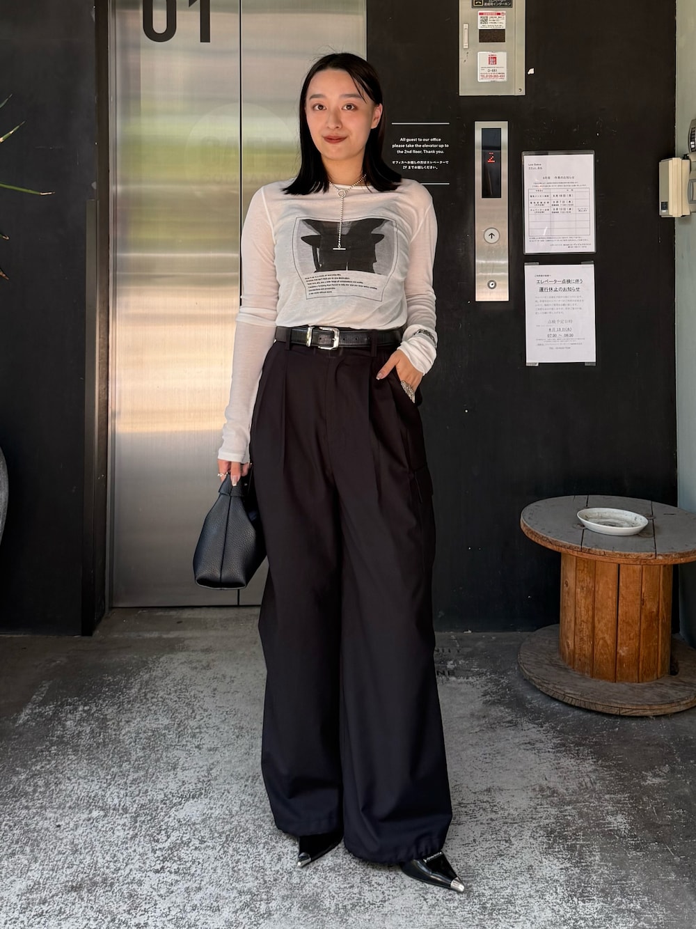 ホワイト系のTシャツ/カットソー、ブラック系のカーゴパンツ、ブラック系のショルダーバッグを着用したレディースの夏コーディネートの1枚目の写真