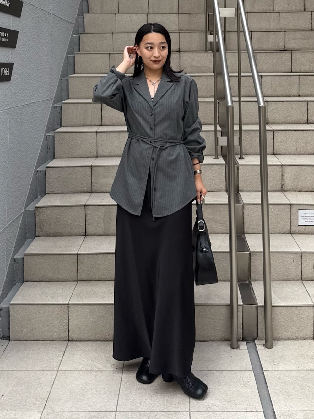 グレー系のシャツ/ブラウス、ブラック系のスカート、ブラック系のブーツを着用したレディースの夏コーディネートの1枚目の写真