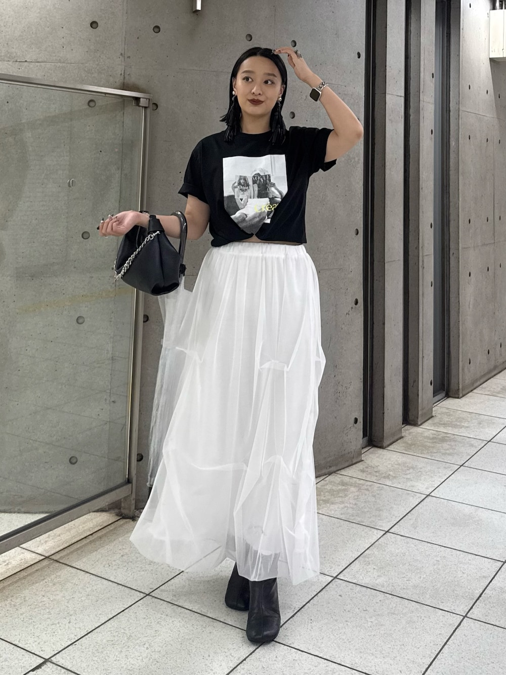 ブラック系のTシャツ/カットソー、ホワイト系のスカート、ブラック系のトートバッグを着用したレディースの春コーディネートの1枚目の写真